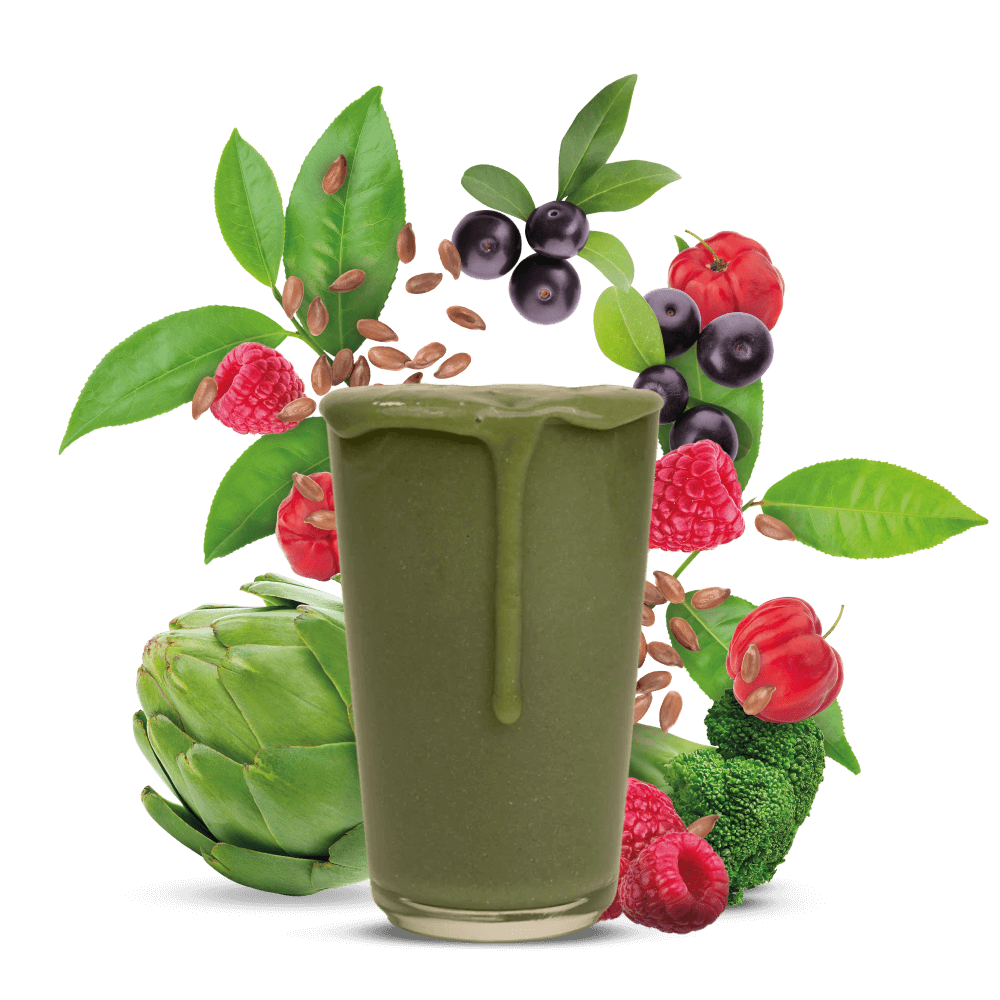 Glas mit Sanamana Shake, dahinter verschiedene Obst und Gemüse Sorten.